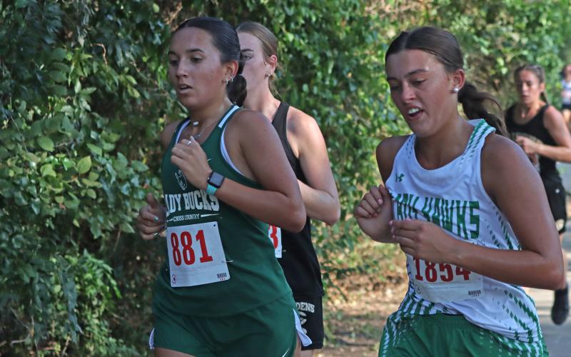 (Photo/Liam Bailey) Abbi Duran runs alongside an Iowa Park runner in the girls’ 2-mile run of the Brownwood Invitational, in which she placed 62nd overall with a time of 14:18.03.