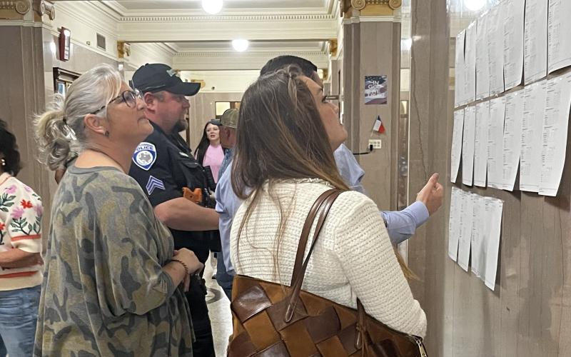 (KEARSTON PARKER, BRECKENRIDGE AMERICAN) Visitors at the Stephens County Courthouse look over election results displayed on the wall Tuesday, March 3 for the primaries. Three local county positions were contested in the election.