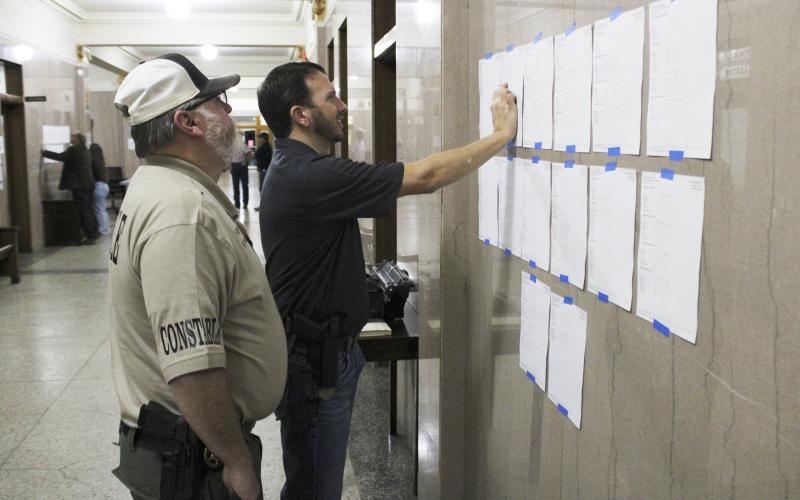 Stephens County Constable Wayne McMullen (left) and Stephens County Judge Michael Roach (right) look at early voting and absentee voting results for the Stephens County Republican and Democratic primary elections at the Stephens County Courthouse. Photo/Mike Williams