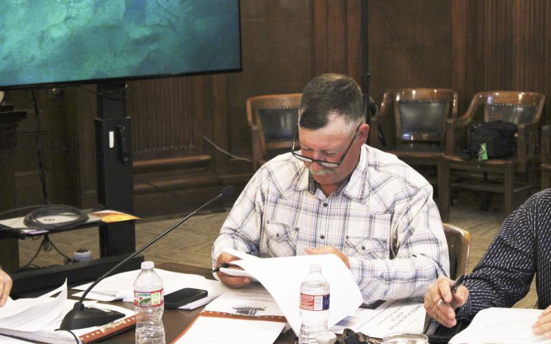 Stephens County Precinct 3 Commissioner Will Warren looks over a draft agreement for a tax abatement for La Casa Wind, LLC during a public hearing and vote Monday, March 11. Photo/Mike Williams