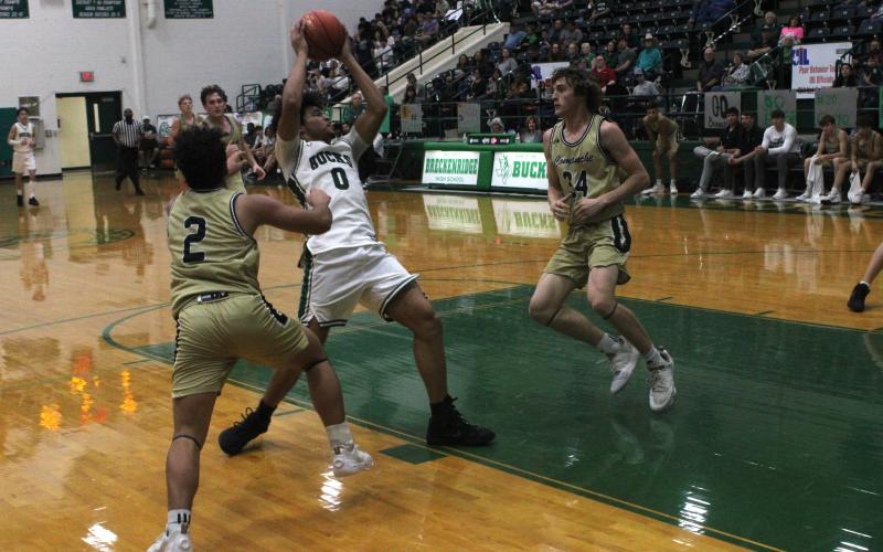 (Photo/Alex Kielar) Douglas White drives into the paint in between two Comanche defenders Friday night, Feb. 13 on Senior Night as the Bucks defeated the Indians. 63-42. 