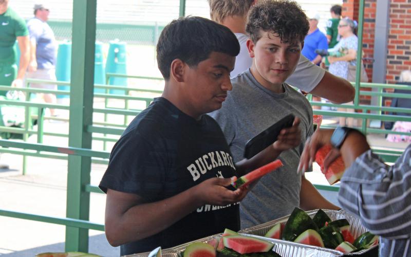 (Photo/Alex Kielar) Players, coaches and families grab watermelon following this year’s Watermelon Scrimmage at Buckaroo Stadium. The Breckenridge ISD board approved the construction of a new concession stand at the southeast end of the stadium. 