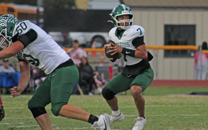 (Photo/Alex Kielar)  Joseph Juneau looks to throw downfield in the opening quarter of the Bucks’ 26-22 win over Comanche in a game that started Friday, Oct. 24 and finished Saturday afternoon.  