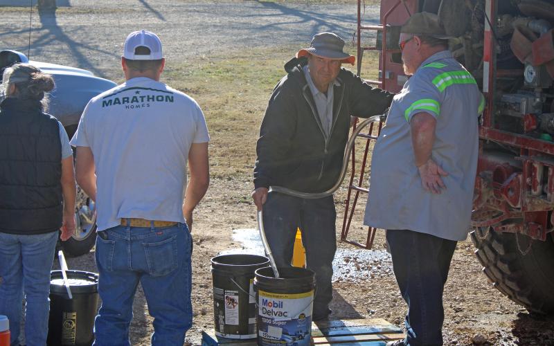 (Photo/Alex Kielar) Volunteers help pump out water from a Wayland VFD tanker Wednesday, Dec. 10 into a resident’s bucket for non-potable water during the city-wide water emergency.
