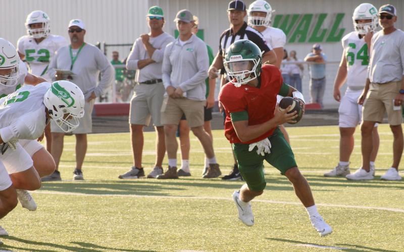 (Photo/Alex Kielar) Quarterback Cooper Wimberly rolls out of the pocket as a couple of Wall defenders rush him during the Buckaroos’ final scrimmage Thursday, Aug. 21 before they start the regular season at home Friday, Aug. 29. 