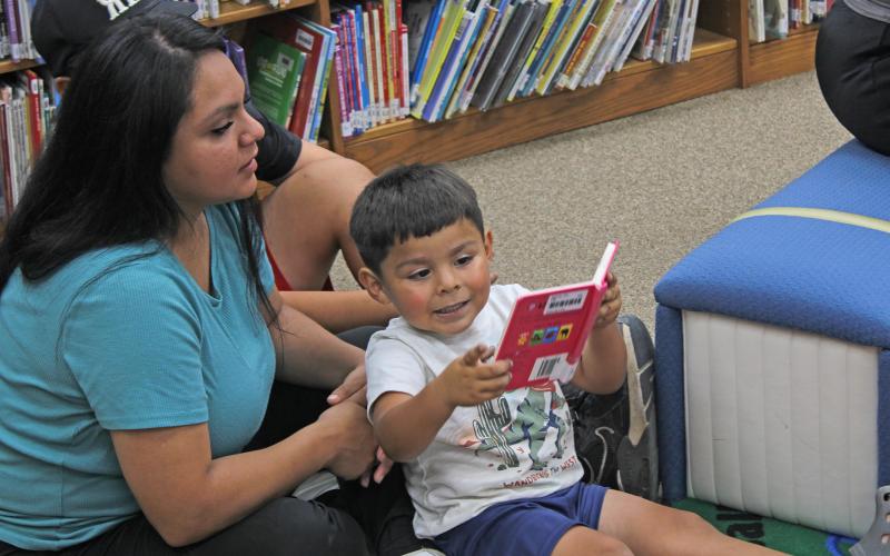 (Photo/Alex Kielar) A young student shows his mom the book he is reading during summer reading at the Breckenridge Library earlier this year. To help improve learning materials for English Language Learners, the libraries at BISD have received a $5,000 youth literacy grant from the Dollar General Literacy Foundation. 