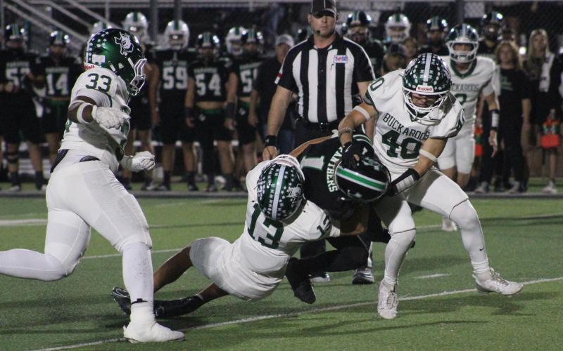 (Photo/Alex Kielar) Ryan Waller (13) and Brenham Walker (40) work to get Paradise ball carrier Logan Lampley down Friday night, Nov. 14, in their bi-district matchup at Mineral Wells Ram Stadium. 