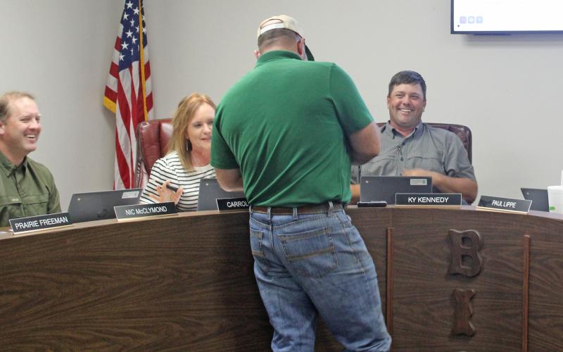(Photo/Alex Kielar) Josh Patterson of Rockin' P Construction LLC shows the BISD school board a draft rendering on his phone of what the approved concession stand construction will look like at the southeast corner of Buckaroo Stadium. 