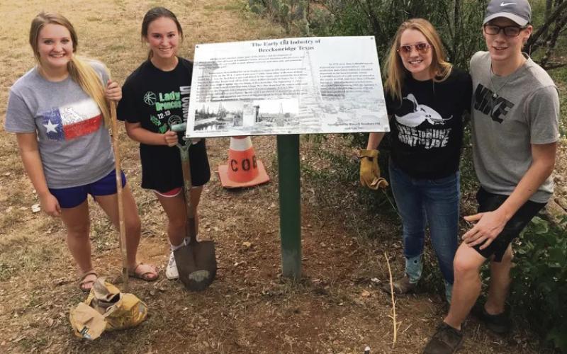 From left, Breckenridge High School students Diana Patterson, Mackenzie Harris, Elyssa Glick and Braxton Post pose for a photo after placing historical markers and planting tress along the walking trail of Miller Park in Breckenrige as part of a project through TMCN.