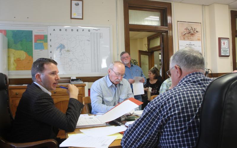 County Judge Michael Roach discusses budgeting with other county commissioners. BA photo by James Norman