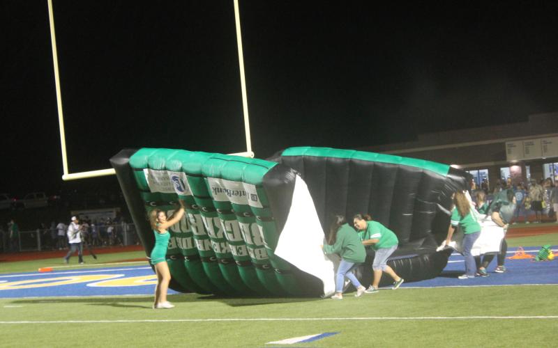 Buckaroo helpers try flip the entrance tunnel and stop it from blowing away before the second half on Friday night. Weather did not do anybody any favors, as the second half had rain throughout. BA photo by James Norman