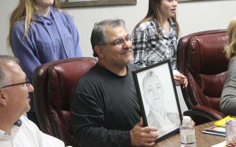 Board Member Pat Escalon holds his portrait up. BA photo by James Norman