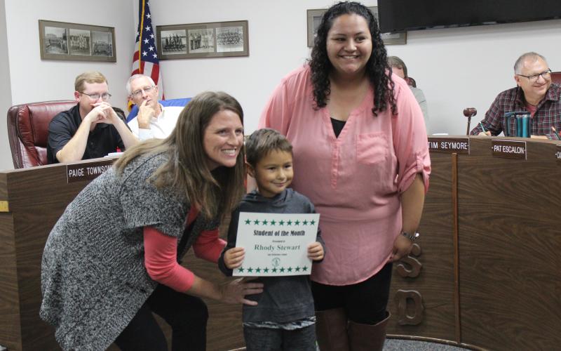 The principal at East Elementary is posing with Kindergarten student Rhody Stewart and his classroom teacher Teresa Guardiola at the BISD board meeting, where he was recognized as the Student of the Month for October. He represented for East Elementary.
