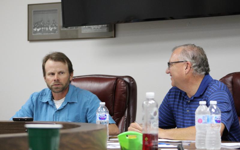 Tim Seymore (right) talks to Board President Graham Reaugh at the BISD school board's May meeting. BA photo by James Norman
