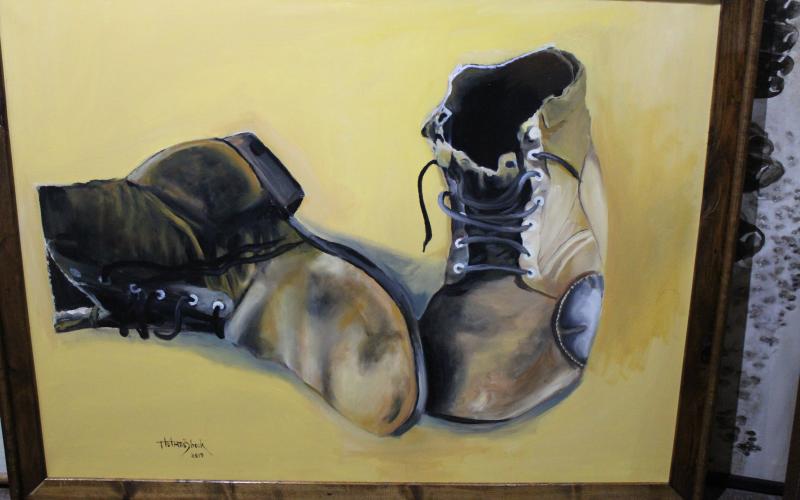 Shook's husband, Clarence, took many photos while he was overseas during the Korean War. This painting was a from a photo he took of his boots while he was in Lourdes, France. BA photo by Jean Hayworth