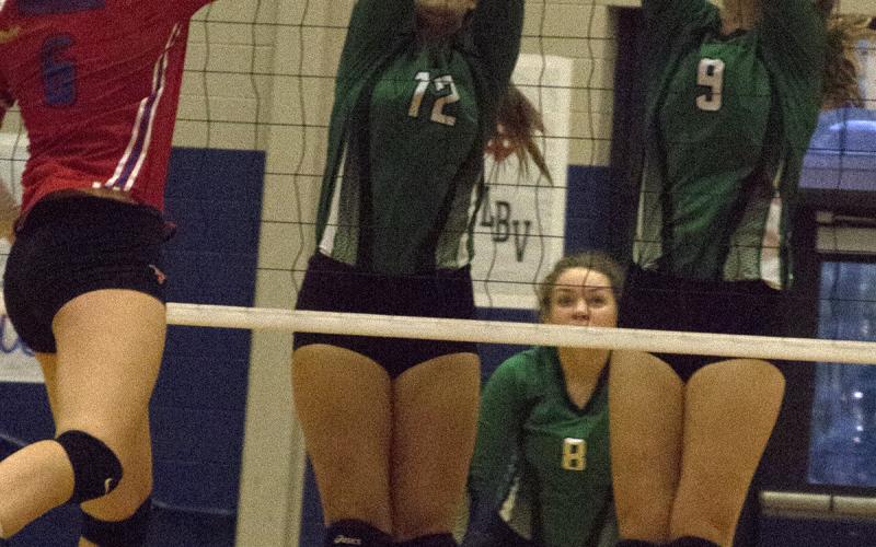 Junior middle hitter Calista Lambert and sophomore outside hitter Madison Stanley block a shot against Graham.