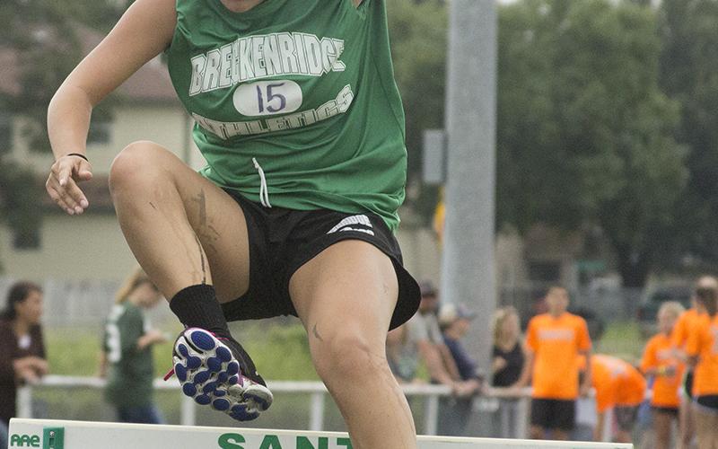 Freshman Nayeli Hernandez leaps over a hurdle after running more than 1.5 miles during the Santo Relay.