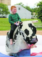 A young boy tries not to get thrown off of a mechanical bull as bull riding was one of the various fun activities that Stephens County Frontier Days goers were able to participate in last Friday, May 2 and Saturday, May 3. Photo/Alex Kielar