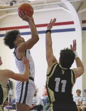 Douglas White (center) shoots during the Bucks’ game Saturday, Dec. 14 against the Amarillo Bushland Falcons, as part of the Red, White &amp; Blue Tournament. Photo/Thomas Wallner