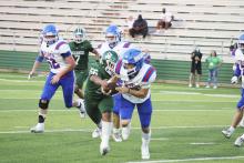 Xavier Rodriguez (56) brings down Bobcats quarterback Drake Rabe for the first of four Buckaroos sacks Friday, Sept. 6 against Childress. Photo/Mike Williams