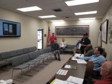 Fire Chief Calvin Chaney shows the commissioners several photos taken of houses from around town that depict substandard living arrangements. BA photo by James Norman