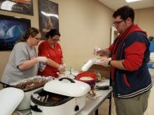 Ivy Delong (middle) works with two of her students to prepare meals. BA photo by James Norman