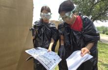 Two Breckenridge High School students look over blood spatter patterns as a part of the forensic science class. The students were split into investigator teams to create spatter patterns on cardboard boxes. (BISD Journalism/Contributed photo)