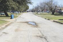 A pot hole filled with water on Hullum Street in Breckenridge. The road is one of many slated to receive repairs in the upcoming year. Photo/Mike Williams