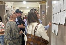 (KEARSTON PARKER, BRECKENRIDGE AMERICAN) Visitors at the Stephens County Courthouse look over election results displayed on the wall Tuesday, March 3 for the primaries. Three local county positions were contested in the election.