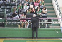 Breckenridge High School students Bianca Gotchall (seated) and Kodee Crawford (on right) receive instruction from Calvin Best, Director of Sports Information and Livestream Media Productions, before a Lady Bucks volleyball match Tuesday, Oct. 17. Photo/Mike Williams