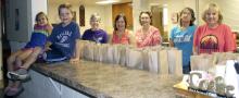 From left, area children Christian Lechner and Ashlyn Owens pose for a photo with volunteers Linda Leveridge, April Lechner, Sharon Toland, Marian Jarvis and Ginger Dittmar during the Feed My Lambs food program.