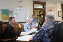 County Judge Michael Roach discusses budgeting with other county commissioners. BA photo by James Norman