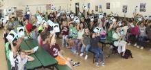 Students at South Elementary hold up their recently donated book “Wonder” as part of a multi-class project.