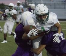 Senior receiver Lonnie Hinson holds onto the ball despite being sandwiched between two Early defenders while making a catch near the goal-line last Thursday.