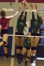 Junior middle hitter Calista Lambert and sophomore outside hitter Madison Stanley block a shot against Graham.